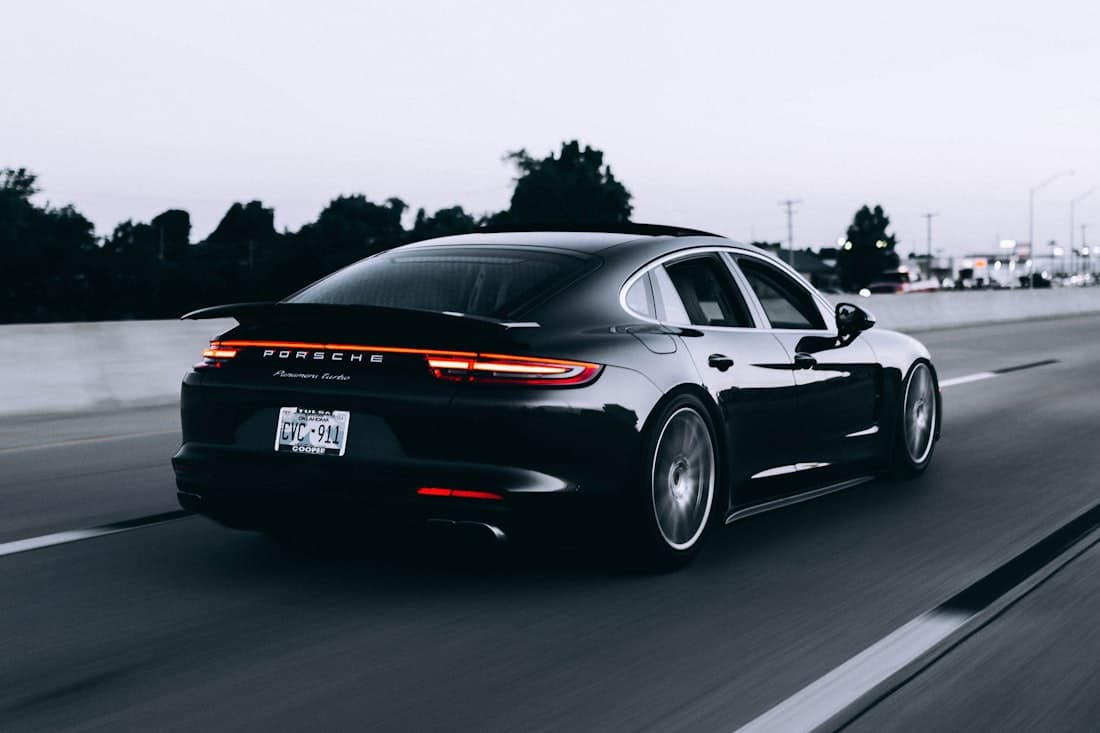 Sedã esportivo preto em movimento ao entardecer — catálogo Vermont Motors